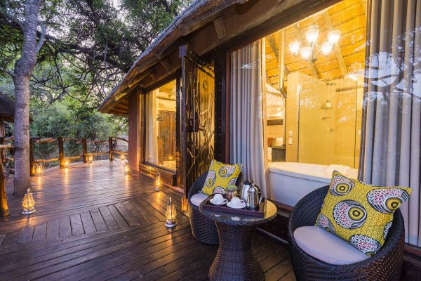 Lemon yellow cushions lift the taupe palette that blends in with the surrounding bushveld outside one of the aha Makalali River Lodge suites.